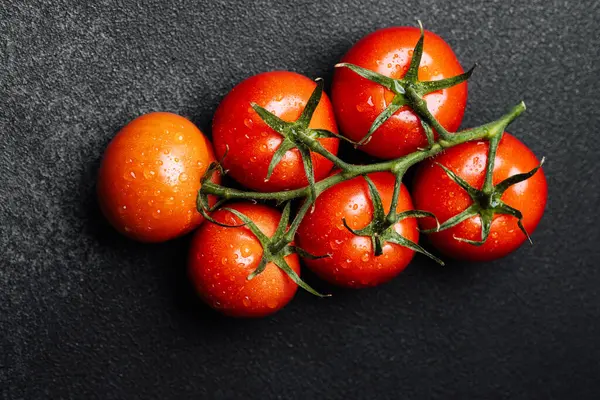 Olgun domates kümesi suyla parıldıyor, tazelik ve kaliteyi gösteriyor..