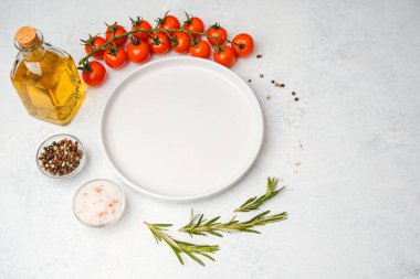Domates, biberiye, tuz, yağ ve biber içeren yemek malzemelerinin bulunduğu boş beyaz tabağın üst görüntüsü