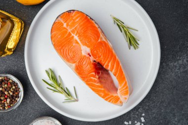 Mutfakta pişirmeye hazır baharat ve otlarla süslenmiş somon filetosu..