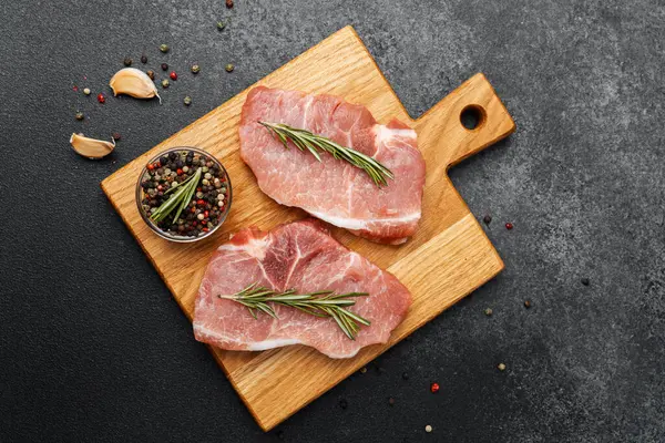 Taze biberiye ve baharatla süslenmiş domuz pirzolası pişirmeye hazır..