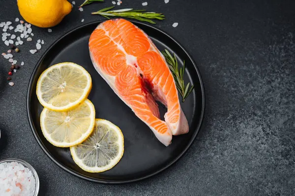 Canlı bir somon filetosu güzel bir şekilde limon dilimleri ve bitkilerle düzenlenir..