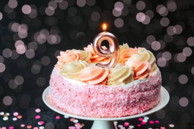 Canlı bir doğum günü pastası, şekerle süslenmiş ve mum bir çocuğun dokuzuncu yaş gününü simgeliyor..