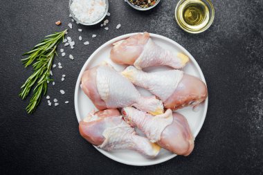 Tavuk budu çiğ, baharatlı ve otlu beyaz tabakta.