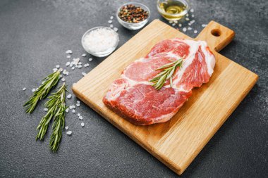 Biberiyeli çiğ biftek ve ahşap tahtada baharatlar.