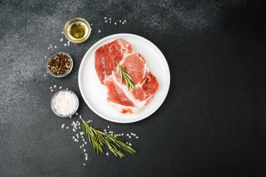 Biberiye ve baharatlı, beyaz tabakta pişmemiş biftek.