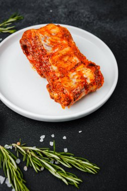 Beyaz tabakta marine edilmiş domuz pirzolası ve baharat.