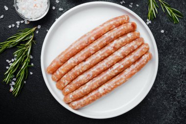 Beyaz tabakta taze domuz sosisi ve baharat.