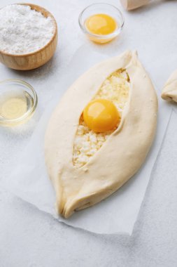 Khachapuri 'nin yumurta sarısı ve unu beyaz masada.