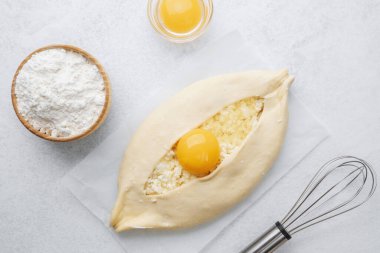 Yumurta sarısı ve beyaz arka planda çırpılmamış khachapuri.