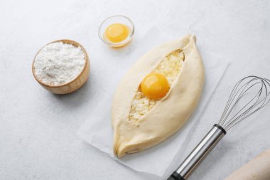 Yumurta sarısı ve beyaz arka planda çırpılmamış khachapuri.