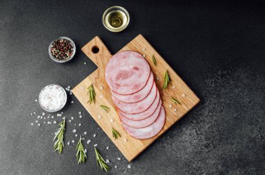 Siyah masa arkasında tuzlu ve biberiyeli dilimlenmiş domuz sosisi.