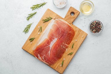 Jambon dilimleri tuz, otlar ve baharatlarla dilimlenmiş.