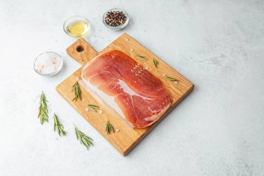 Jambon dilimleri tuz, otlar ve baharatlarla dilimlenmiş.