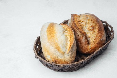 Tezgahın üzerinde dokuma sepetinde dinlenen iki ekmek somunu..