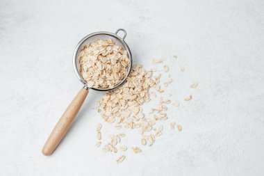 Kurutulmuş yulaflar hafif bir yüzeyde metal süzgeç kullanılarak ayıklanıyor..