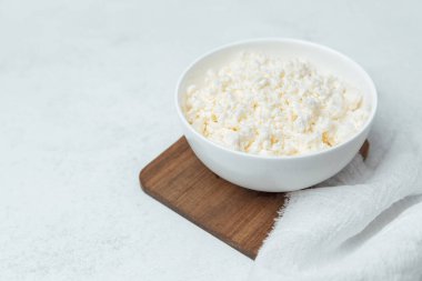 Bir kase kabarık, beyaz patlamış mısır mutfaktaki tahta bir tahtanın üzerinde duruyor..