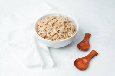 Lezzetli bir kase pişmiş yulaf ezmesi yanında tahta kaşıklarla servis etmeye hazır..