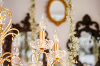 Kristalleri ve klasik aynaları olan bir avize dekorda şık bir ortam yaratır..