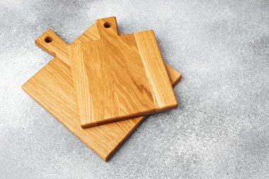 Üç tahta kesim tahtası işçiliklerini gri arka planda sergiliyor..