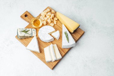 Çeşitli bal çeşitleri ve tatları içeren davetkar bir peynir düzenlemesi..