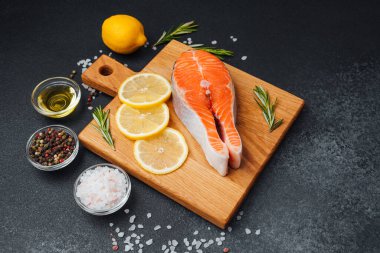 Limon dilimleri ve otlarla birlikte kesilmiş somon filetosu..