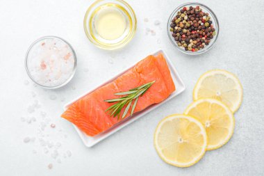 Baharatlarla ve tezgahta limon dilimleriyle süslenmiş somon filetosu.