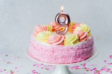 Pembe ve sarı kremalı renkli pasta, bir çocuğun dokuzuncu yaş gününü kutluyoruz..