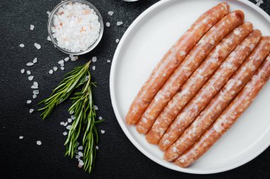 Beyaz tabakta taze domuz sosisi ve baharat.