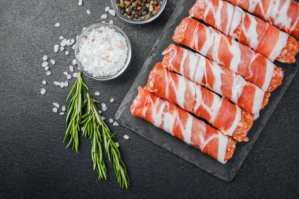 Jambona sarılmış sosis siyah tahta ve baharatlı.