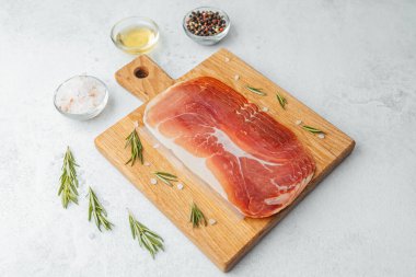 Jambon dilimleri tuz, otlar ve baharatlarla dilimlenmiş.