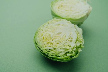 Yeşil arka planda iç dokuyu gösteren yarım yeşil lahana.