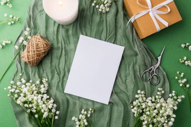 Mumlu boş kart, hediye ve yeşil kumaşta bahar çiçekleri.