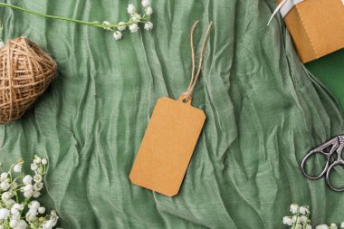 Çiçekli kraft etiketi ve hediye paketi aksesuarlarının üst görünümü