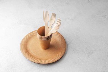 Beyaz arka planda tek kullanımlık tabakta ahşap çatallı eko kağıt bardaklar.