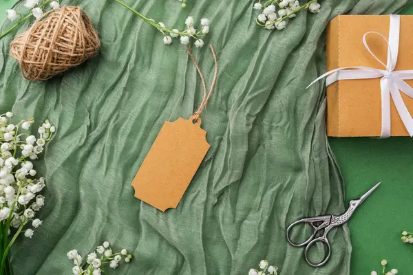 Çiçekli yeşil kumaş ve ambalaj aksesuarlarıyla hediye etiketi