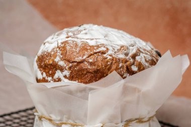 Geleneksel paskalya pastası, pudra şekeri ve parşömen kağıdında benekli yumurta. Bahar tatili için şenlikli gıda konsepti.