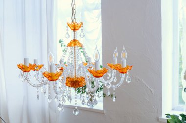 Turuncu aksanlı ve kristalli avize oda dekorunu güzelleştiriyor..