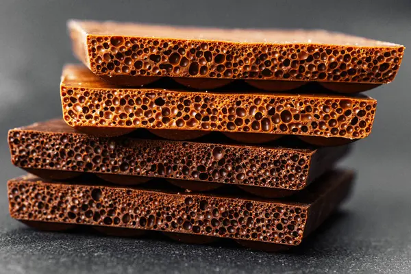 Koyu renkli sırtüstü havalanmış sütlü çikolata parçaları yığını.