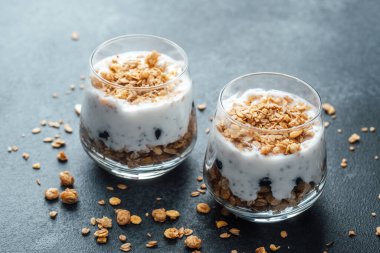 Koyu arkaplanda granola ve yoğurtlu parfümler.