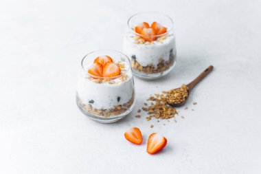 Dilimlenmiş çilek ve tahıl gevreğiyle kaplı yoğurt parfe.