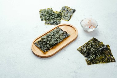 Beyaz arka planda bir kase tuzlu kavrulmuş yosun atıştırmalığı