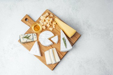 Tahtaya dizilmiş bal ve süslemelerin yanında peynirlerden oluşan bir seçim..