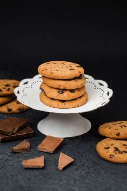 Taze pişmiş çikolatalı kurabiyeler tezgahın yanında çikolata parçalarıyla sergileniyor..