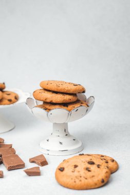 Çikolata parçalı kurabiyeler beyaz bir stantta çikolata parçalarıyla güzelce sergilenir..