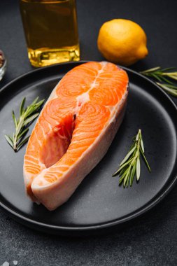 Biberiye, limon ve zeytinyağıyla sunulmuş somon bifteği.