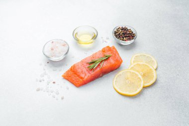 Somon filetosu biberiye, limon dilimleri ve pişirmeye hazır baharatlarla süslenir..