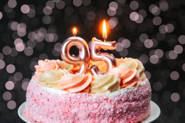 95 numaralı lezzetli pembe pasta. Arka planda yanan mumlar var..