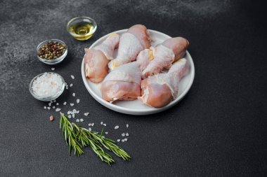 Tavuk budu çiğ, baharatlı ve otlu beyaz tabakta.