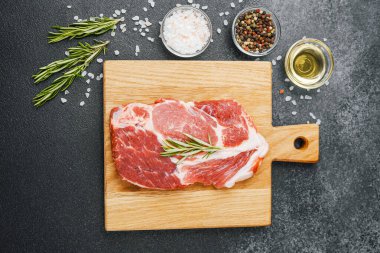 Biberiyeli çiğ biftek ve ahşap tahtada baharatlar.