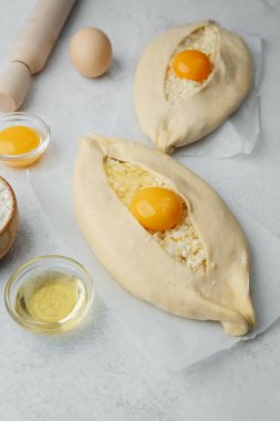 Yumurta sarısı ve beyaz arka planda çırpılmamış khachapuri.